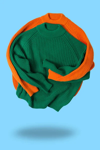 Δύο Μάλλινα Πλεκτά Πουλόβερ Πράσινο Και Πορτοκαλί Διπλωμένα Σαν Αγκαλιάζει — Φωτογραφία Αρχείου