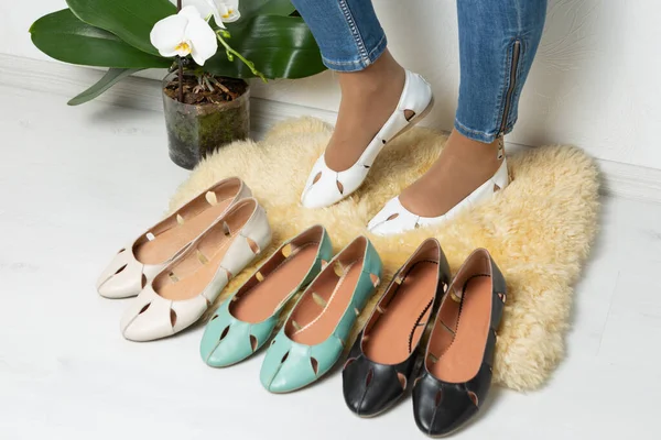 Frauenbeine Weißen Ledersommerschuhen Umgeben Von Einem Sortiment Schuhen Minimales Konzept — Stockfoto