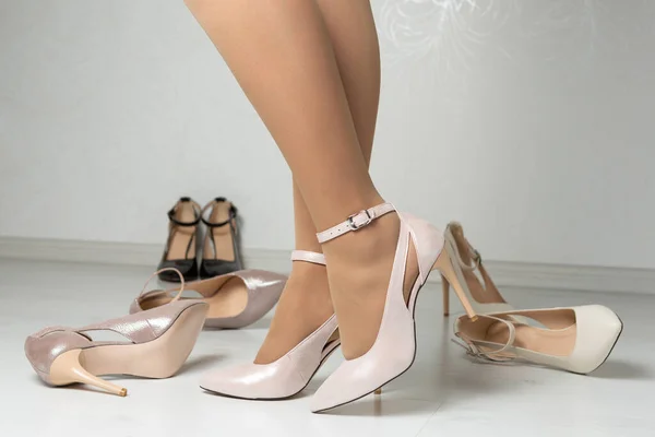 穿着漂亮高跟鞋的女性腿 散落在鞋子旁边 购物理念 — 图库照片