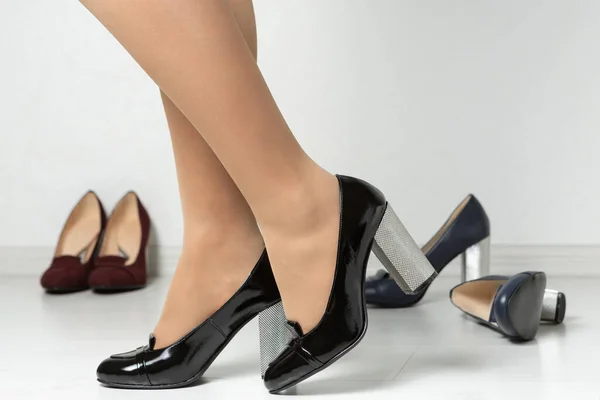 Piernas Femeninas Zapatos Tacón Alto Negros Rodeados Una Variedad Zapatos — Foto de Stock