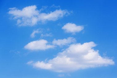 Mavi gökyüzünde çaprazlama dizilmiş, farklı boyutlarda beyaz bulutlar.