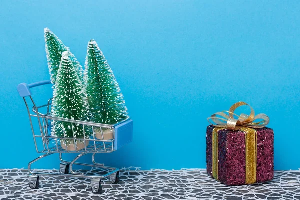 Concept Van Kerstinkopen Een Supermarkt Kar Drie Kerstbomen Naast Een — Stockfoto