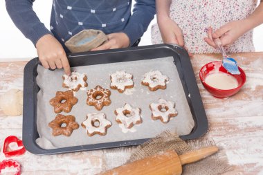 christmas concept, children hands, boy and girl decorate christmas cookies