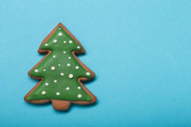 honey gingerbread in the form of a Christmas tree on a pastel turquoise background, minimal christmas concept