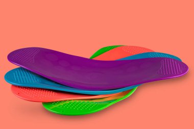 four multi-colored balancing boards for fitness, an assortment of plastic balancing platforms, on an orange background, concept