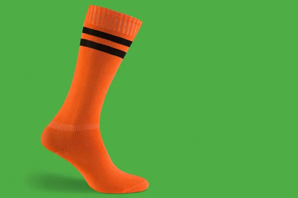Orangefarbene Voluminöse Fußballleggings Auf Grünem Hintergrund Mit Schatten Konzept Kopierraum — Stockfoto