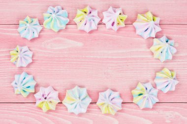 Şenlikli arka plan kavramı, oval çok renkli kremalı pembe tahta tahtalarda.