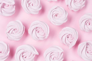 Bir sürü marşmelov, ev yapımı elma pembesi marşmelovlar pembe arka planda serili.