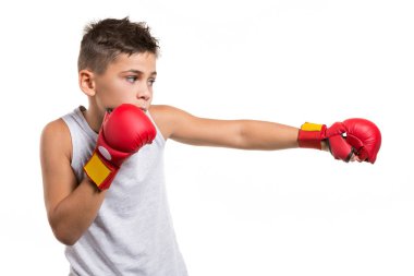 Karateci çocuk dövüşüyor, elleriyle vuruyor, ellerinde kırmızı eldivenler, beyaz arka planda, izole edilmiş.