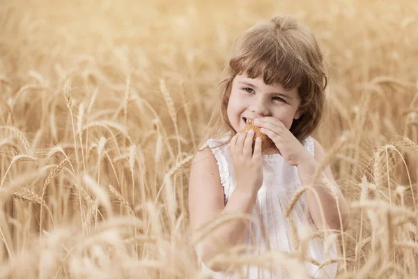 Menina Campo Trigo Bebê Morde Pão Sorrindo Conceito Espaço Cópia — Fotografia de Stock