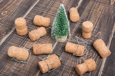 Minimum Noel konsepti, eski tahtalardaki dekoratif Noel ağacı, etrafa saçılmış şampanya mantarları.