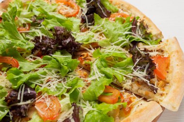 Klasik İtalyan pizzası, marul ve domates, pizza kesimi, yakın çekim.