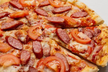 İtalyan pizzası, füme sosis, domates, pizza dilimi, yakın çekim.