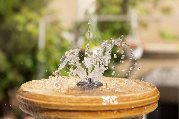 緑の背景に水のある小さな噴水 たくさんの水のジェット 水と夏のコンセプト — ストック写真