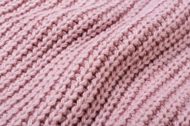 Pembe örülmüş kumaş. Çaprazlama serilmiş. Büyük kıvrımlı, desenli arka plan.