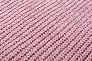 Pembe örülmüş kumaş. Çaprazlama serilmiş. Kabaca örülmüş, desenli arka planda.