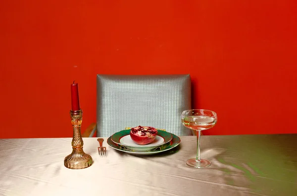 Eski masa gözlükleri kırmızı arka plan nar koltuğu plaka mum şarap.