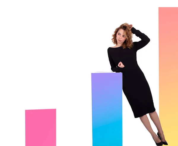 Siyah elbiseli güzel bir iş kadını beyaz arkaplanda renkli çizelgelerin yanında.