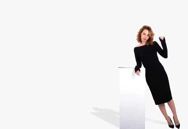 Beyaz arka planda beyaz tüzüğe yakın siyah elbiseli güzel bir iş kadını.