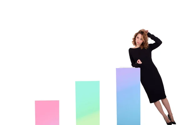 Siyah elbiseli güzel bir iş kadını beyaz arkaplanda renkli çizelgelerin yanında.