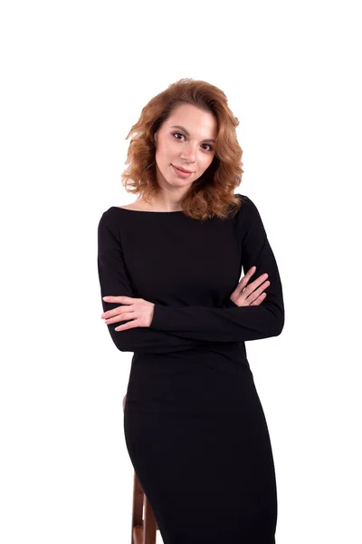 Siyah elbiseli güzel iş kadını beyaz arka planda bir şeyin hayalini kuruyor.