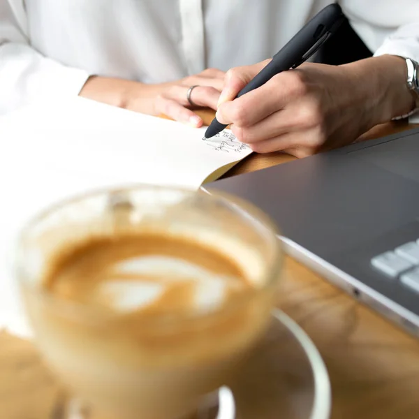 Ön planda beyaz gömlekli bir iş kadını olan şeffaf kahve kapuçinosu.