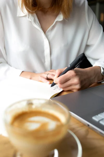 Ön planda beyaz gömlekli bir iş kadını olan şeffaf kahve kapuçinosu.