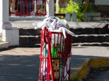 Mahalle meydanında çöp tenekesi dolu.