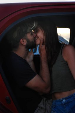 Genç aşıklar birbirlerine sarılıp bakıyorlar.