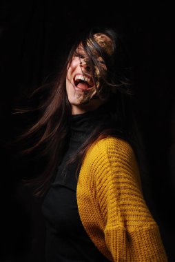 Koyu arkaplanı olan bir kadının yüz ifadesi