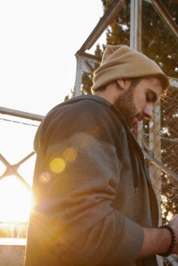 Akıllı telefonuyla gün batımını izleyen bir çocuk.