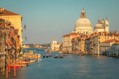 Grand canal with pier of gondolas at peaceful sunset near Rialto, Venice, Italy. 