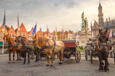 Bruges market square with flemish architecture and horses, Belgium