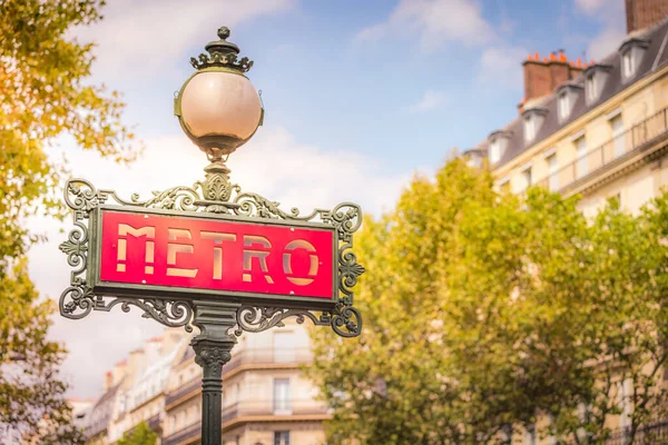 Ornate retro Metro sign entrance in Paris at sunrise with lamp, France