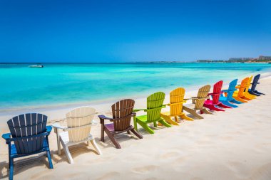 Idyllic beach with rustic wooden adirondack chairs in Aruba, Dutch Antilles