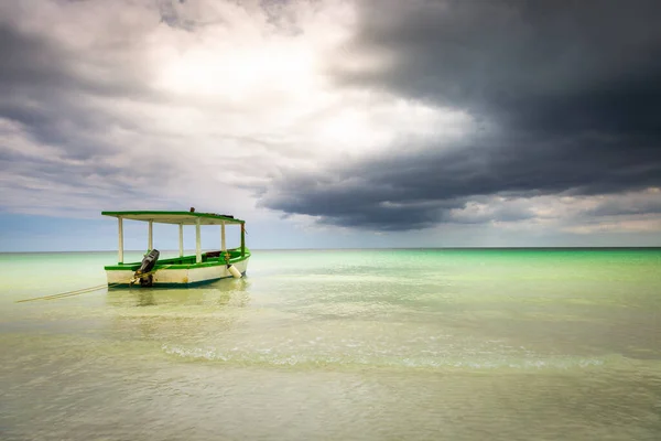 Dramatic sky with storm clouds over caribbean beach with motorboat, Negril Seven Mile Beach, Jamaica