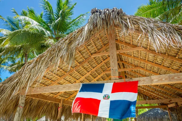 Rustic palapa thatched roof with Dominican Republic Flag in Punta Cana, Caribbean