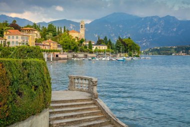 Idyllic Lake Como coastline with Tremezzo village and sailboats at sunny day, Northern Italy