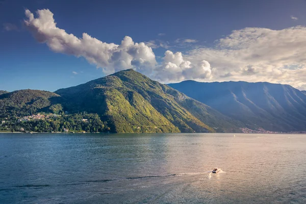 Mountain and boat on Lake Como near Bellagio at sunset, northern Italy