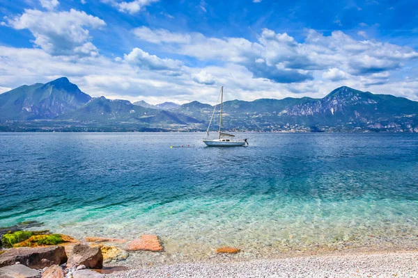 Kuzey İtalya 'da yelkenli ve dağları olan Malcesine' deki Idyllic Gölü Garda sahili.