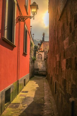 Altın gün batımında Meryem Ana sunağı olan Sorrento sokağı, Güney İtalya, Napoli Körfezi.