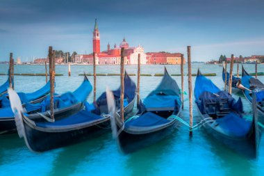 Gondole, Büyük Kanal 'da ahşap demirleme direkleriyle kenetlendi ve akşam San Giorgio Maggiore Kilisesi, Ethereal Venice, İtalya