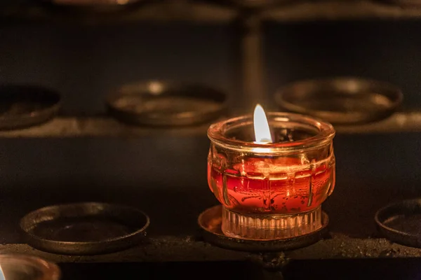 Background with one candle of prayers in the cathedral of Notre Dame, Paris