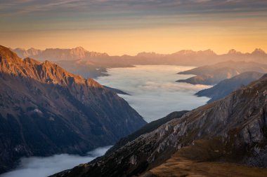 Grossglockner 'ın yukarısındaki puslu vadi ve dağ manzarası dramatik şafakta, Avusturya alp.