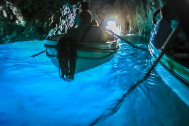 Canoes Inside idyllic turquoise grotto, Capri blue cave, Italy clipart