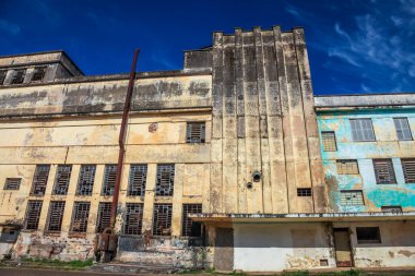 Güneşli bir günde tuğla bacalı terk edilmiş ve çürümüş bir fabrika.