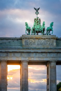 Brandenburg Kapısı, Brandenburger Tor, Berlin, Almanya 'da dramatik günbatımı gökyüzünde