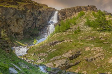 İlkbaharda ruhani şelale ve alp çayırları, Gran Paradiso Alpleri, İtalya, Fransa sınırı