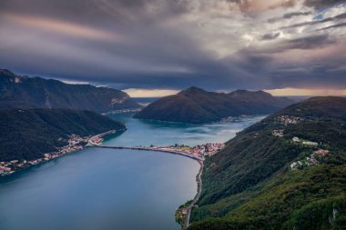 İsviçre 'nin İsviçre Alplerinde Lugano Gölü üzerinde dramatik günbatımı