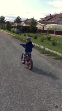 POV dikey video hikayeleri. 4-5 yaşlarında tatlı bir çocuk. Güneşli yaz gününde bisiklete binen küçük bir çocuk. Parkta oynayan ve bisiklete binen bir çocuk.